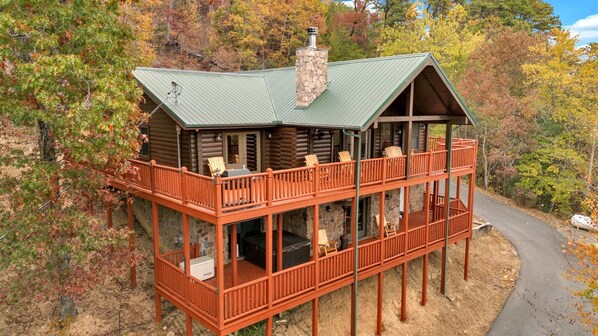 A cabin with a stone chimney, wooden deck, and a covered porch. - Walden's Ridge Cabin 4 Bedroom Cabin (Sevierville)
