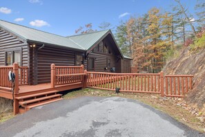 A log cabin with a porch and a fenced deck. - Walden's Ridge Cabin 4 Bedroom Cabin (Sevierville)