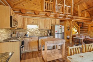 Un interno rustico con cucina, zona pranzo e una scala.