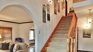 A staircase with wooden railings and carpeted steps, leading to a second floor.