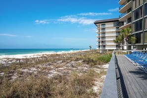 A beachfront hotel with a boardwalk, beach, and ocean view.