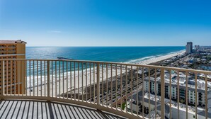A balcony with a view of a beach and cityscape. - Sandy Feet Retreat | Ocean View, Beach Access | Activity Deals (Panama City Beach)