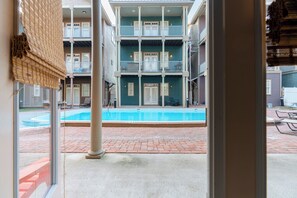 A multi-story building with a swimming pool in the courtyard. - SeaEsta Luxe Retreat | Pool, Walk to Beach | Activity Opportunities (Panama City Beach)