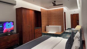 Una habitación de hotel moderna con un armario grande, una bañera y un ventilador de techo.