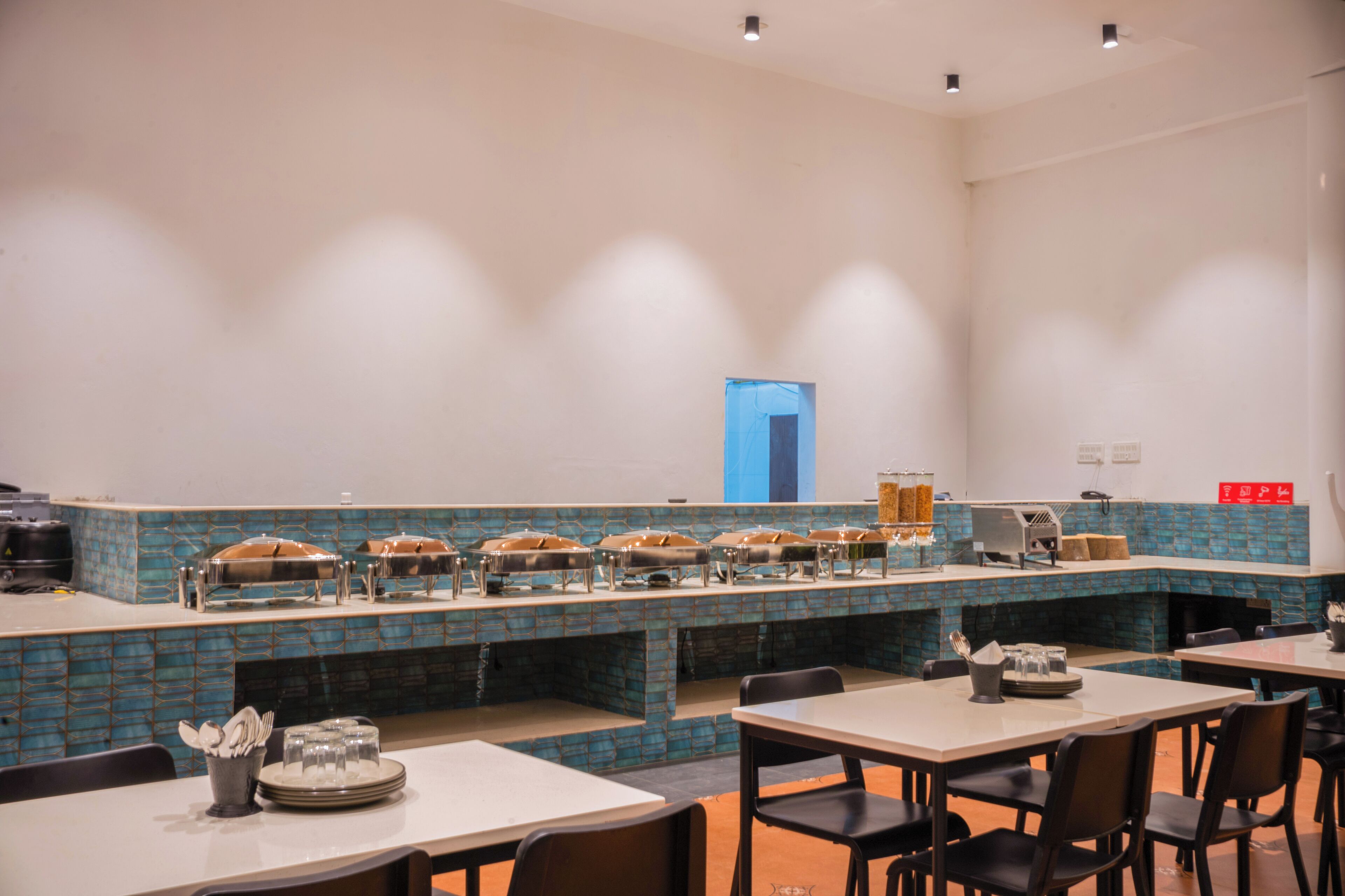 A buffet-style restaurant with multiple serving stations and a blue-tiled backsplash.