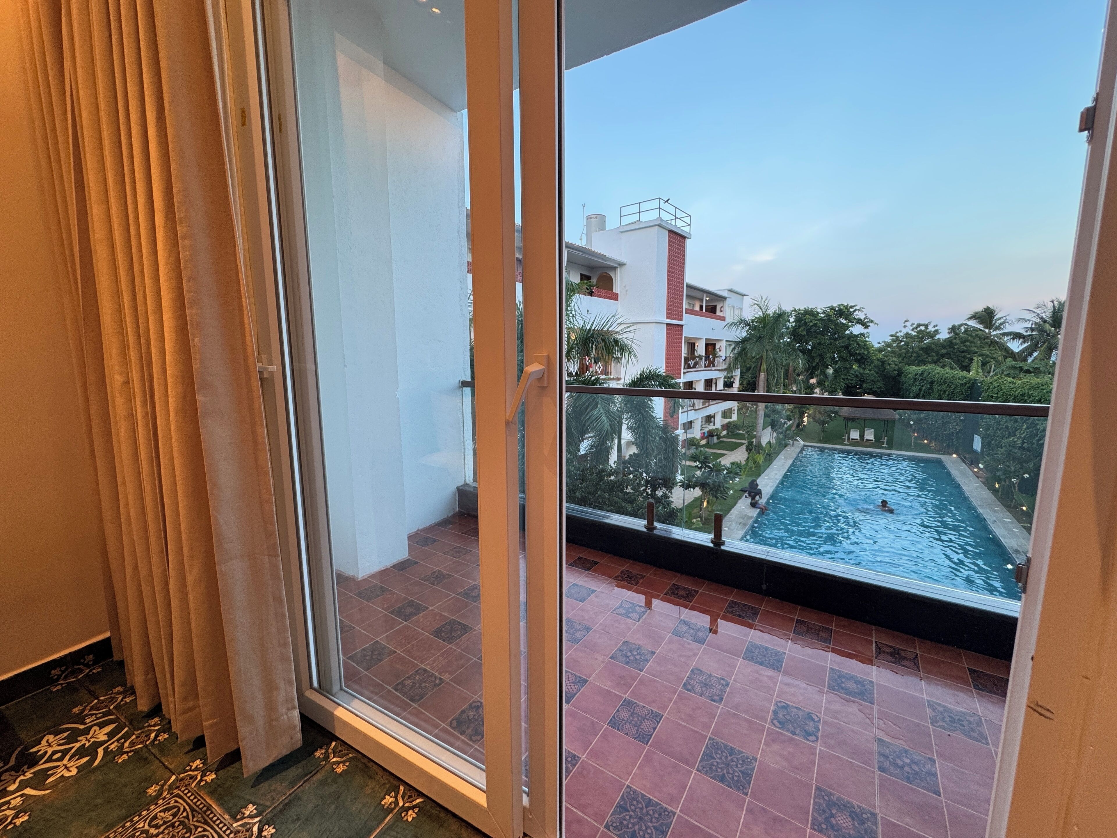 Un balcon donnant sur une piscine et un immeuble doté de balcons.