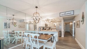 Una cocina moderna con armarios blancos, una isla de madera y un cartel que dice 'welcome'.