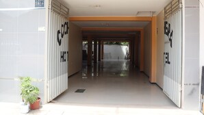 A hallway with a potted plant, a sign with the number 1272, and a door with the letters "EL" on it. - Hotel Virrey (San Ramón)