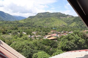 A mountainous landscape with scattered buildings and dense greenery. - Hotel Virrey (San Ramón)