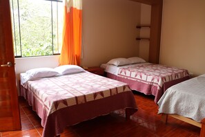 A room with two beds, wooden flooring, a window with curtains, and a shelf unit. - Hotel Virrey (San Ramón)