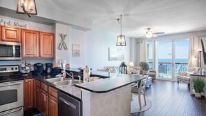 Une cuisine moderne avec des meubles en bois, un four encastré et un grand îlot central doté d’un évier.