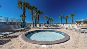 A pool area with lounge chairs, palm trees, and a clear blue sky. - Once Upon A Dream | Beachfront, Pools | Activity Passes (Panama City Beach)