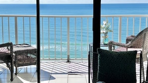 A balcony with wicker furniture and a view of the ocean. - Once Upon A Dream | Beachfront, Pools | Activity Passes (Panama City Beach)