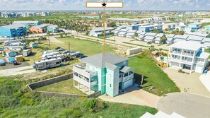 A residential area with multiple two-story houses, a small commercial building, and a trailer park.