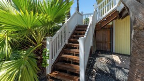A wooden staircase with white railings leading to a wooden deck. - Private Pool | Pets | Sleeps 7 | Long Term Stays (Port Aransas)