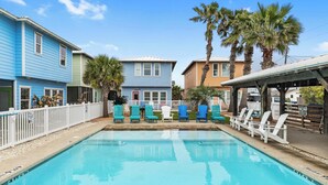 A swimming pool with lounge chairs and palm trees. - Prime Location 5 Bedrooms | Pool | Sleeps 12 (Port Aransas)