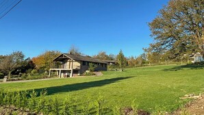 Ett tvåvåningshus med en veranda på framsidan och en gräsmatta på förgrunden.