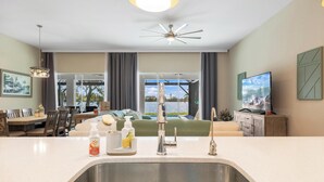 Een moderne keuken met een groot eiland, een roestvrijstalen spoelbak en een plafondventilator.