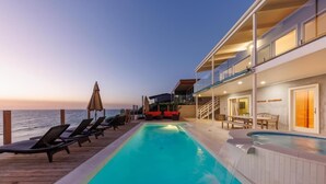 A poolside area with lounge chairs and a small pool, overlooking the sea. - Oceanfront Luxury with Pool/Spa, Beach Access (Encinitas)