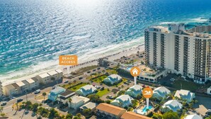 A coastal hotel with beachfront access, multiple-story buildings, and a pool area.