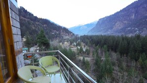 Un balcone con sedie in vimini che si affaccia su un paesaggio montuoso.