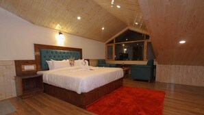 Una camera da letto con soffitto in legno, un letto grande, un tappeto rosso e una finestra.