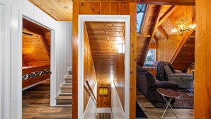 Ein Holzinnenraum mit einer Treppe zu einem Erker, einem Sofa und einem Tisch.