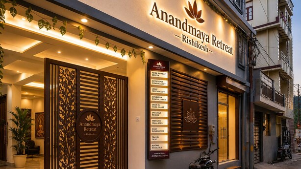A building with a sign reading 'Anandmaya Retreat - Rishikesh' and a list of services including yoga, astrology, and treks. - Anandmaya Retreat Tapovan Rishikesh (Rishikesh)