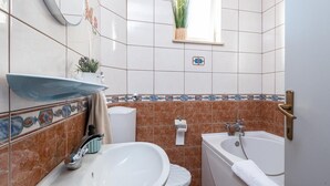 A bathroom with a sink, toilet, and bathtub. - Beautiful 2-Bedroom Apartment with Balcony and Sea View. (Orebic)