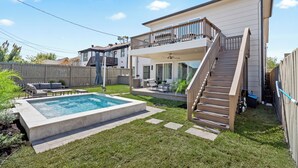 A two-story house with a backyard pool, a covered patio, and a staircase leading to the upper level.
