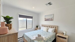 A bedroom with a bed, bedside tables, a window, a plant, and a painting on the wall. - Casa Del Batson - Your home away from home (Robe)