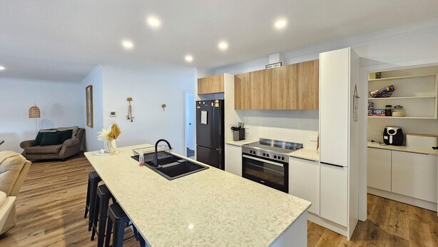 A modern kitchen with a central island, wooden cabinets, and a built-in oven. - Casa Del Batson - Your home away from home (Robe)
