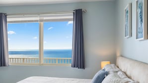 Une chambre avec un grand lit, une vue sur la mer et un balcon.