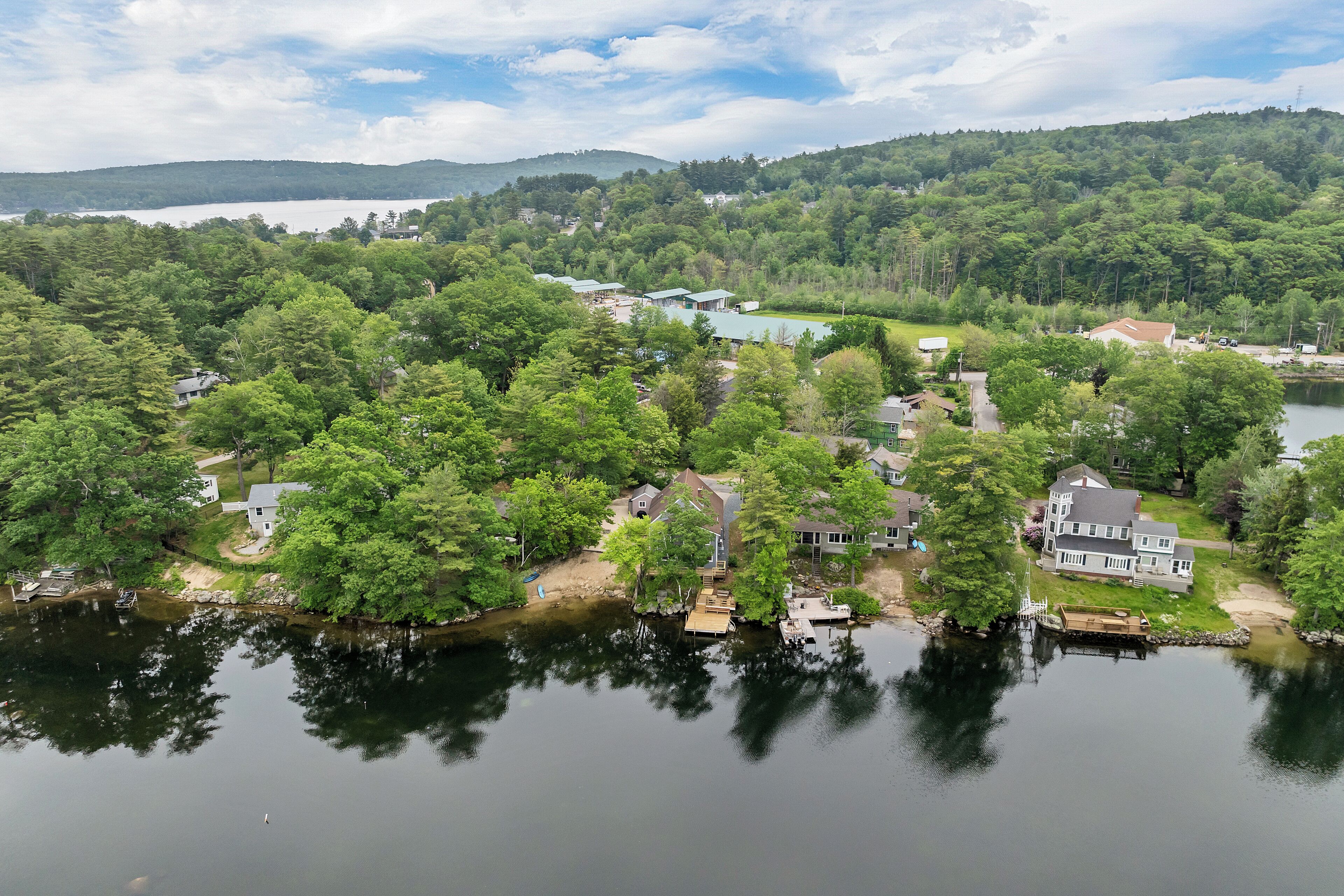 A lakeside residential area with houses, docks, and a boat.