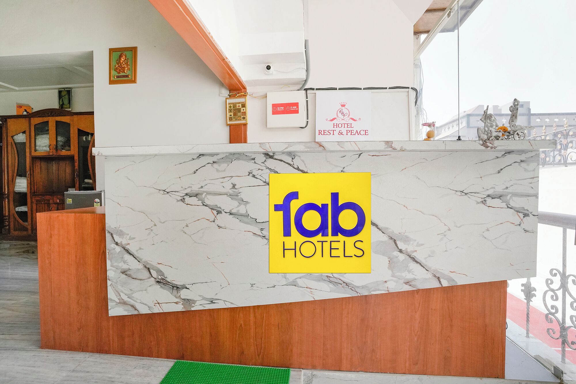 A hotel reception desk with a marble countertop and a sign reading "fab hotels".