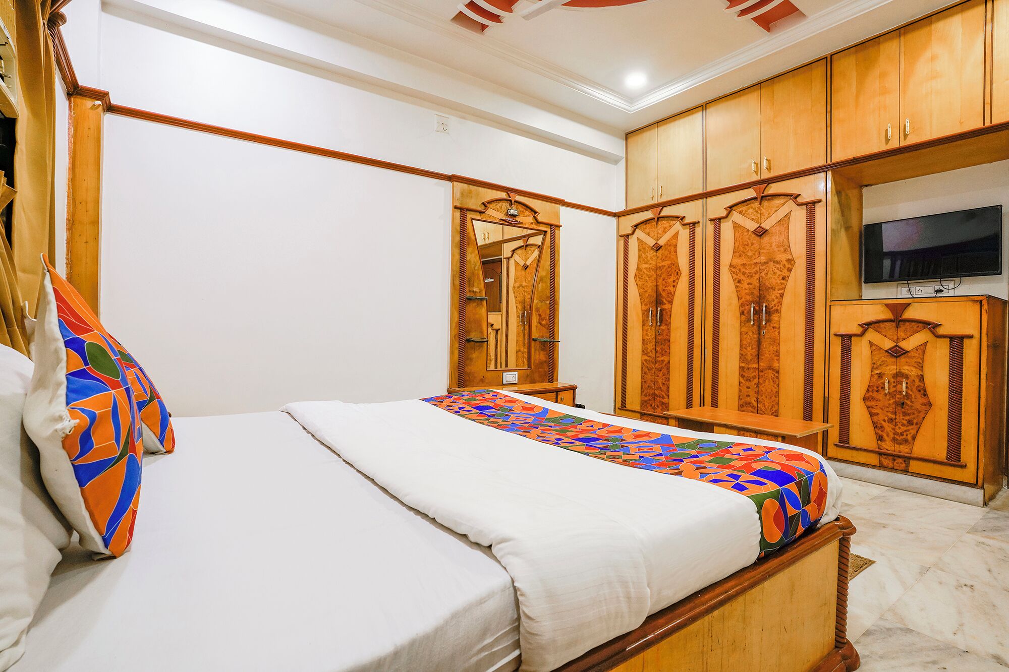 Un dormitorio con cama, armario de madera y televisor.