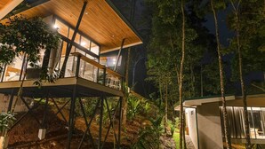 A modern house with a wooden deck, glass windows, and a view of the surrounding forest. - Bungalow Heliconia I Tropical I Quiet I La Fortuna (Provinz Alajuela, San Carlos, Costa Rica)