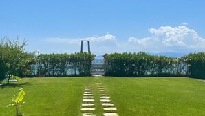 A pathway leading to a gate with a view of the sea.