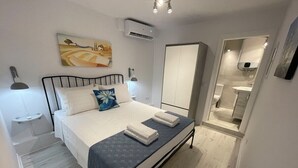 A bedroom with a bed, bedside tables, a wardrobe, and an air conditioning unit.