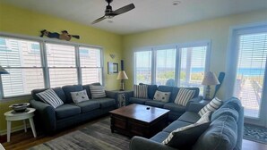 A living room with a sectional sofa, a coffee table, and a ceiling fan.