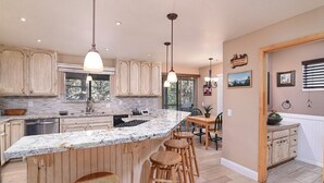 A spacious kitchen with a large island, wooden cabinets, and pendant lighting. - RH465- Ultimate Mountain Retreat (Zephyr Cove)