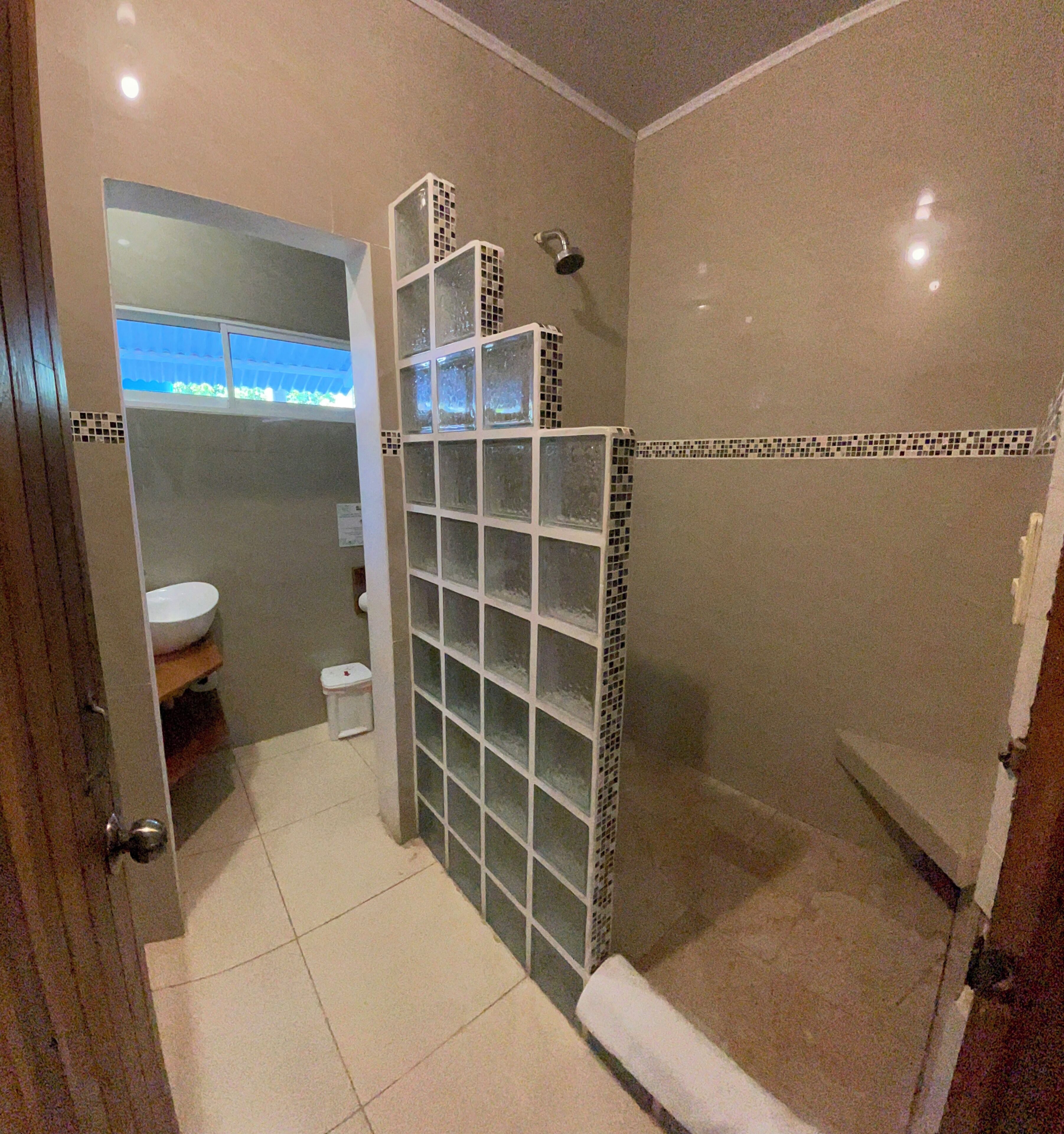 A bathroom with a toilet, sink, and shower.