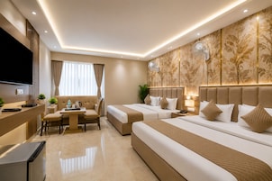 A hotel room with a bed, bedside tables, a desk with a chair, a TV, and a large window with curtains.