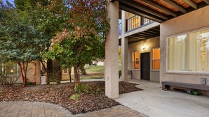 A modern building with a brick pathway, large windows, and a covered entrance.
