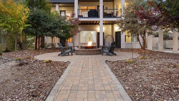 A two-story building with a fire pit in the center, surrounded by chairs.