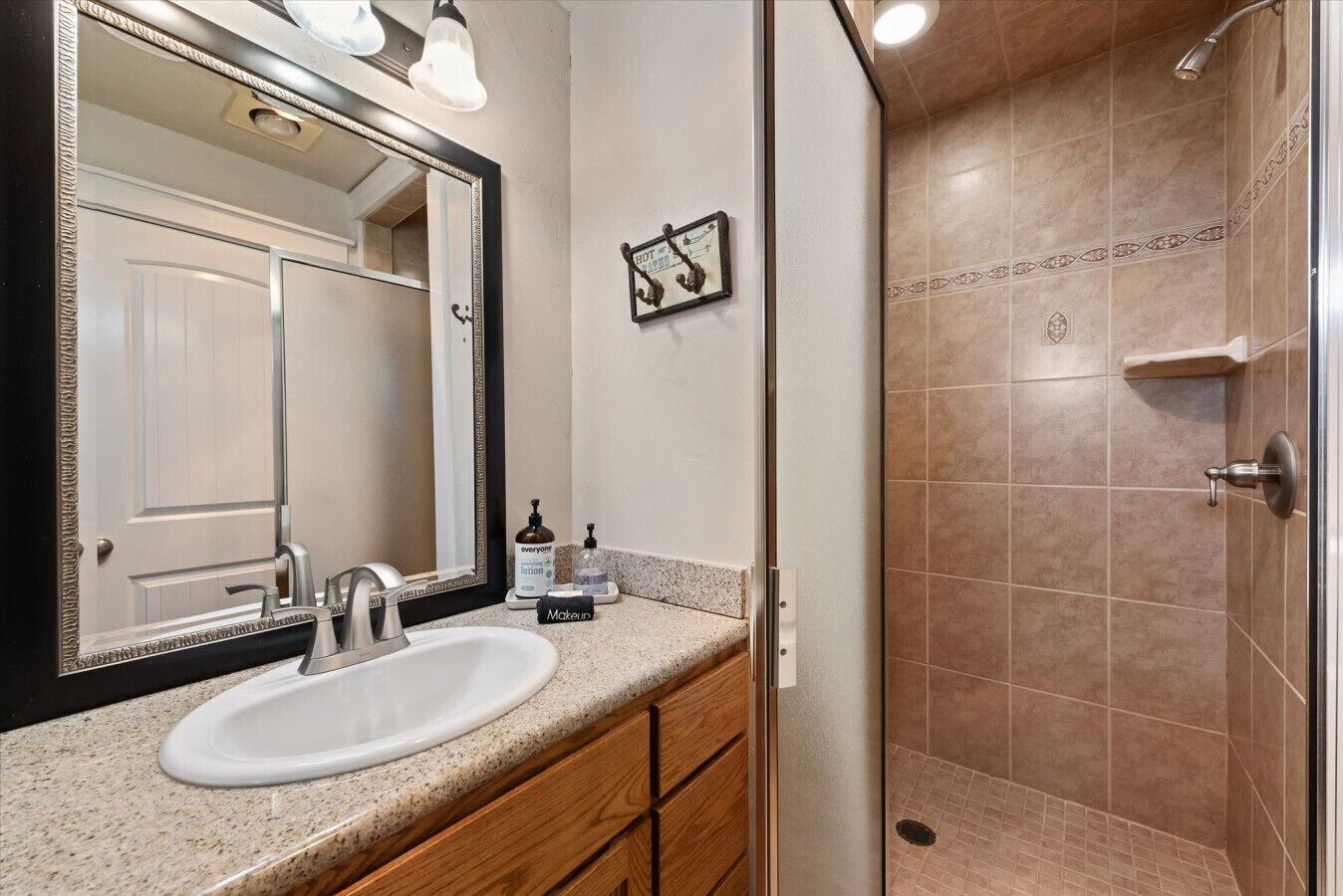 Full bathroom with large vanity, separate toilet room, closet, and tile shower.