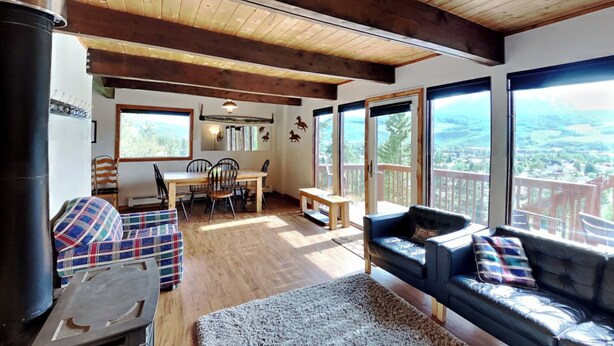 Ein gemütliches Wohnzimmer mit Kamin, Essbereich und großen Fenstern mit reizvollem Ausblick.