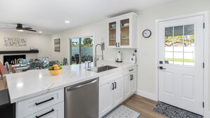 A modern kitchen with white cabinetry, a stainless steel dishwasher, and a marble countertop. - 3 Bedrooms/2 Bath, Pool & Hot Tub, King Beds, Full Kitchen, Garage, EV Charger (Tempe)