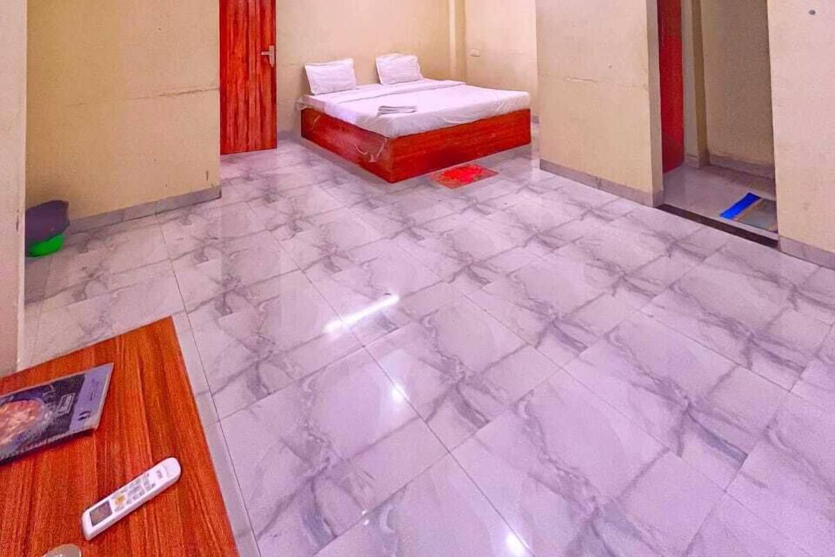 Un dormitorio con cama, ventiladores de techo y una puerta roja.
