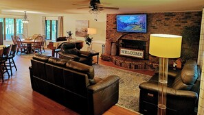 Una sala de estar con chimenea, televisor y sofá.